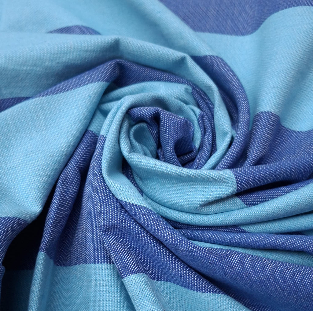 Dettaglio ravvicinato della trama in cotone intrecciato del telo mare Fouta a righe azzurre e blu.